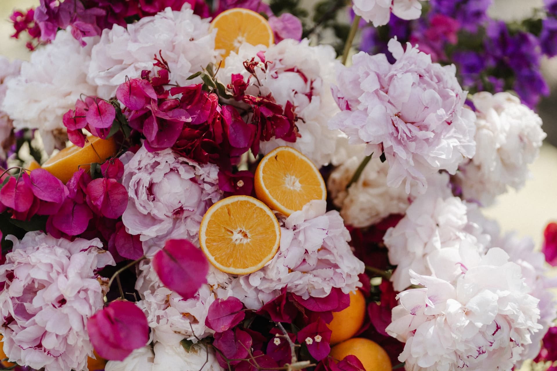 Detail des Blumenarrangements mit halbierten Orangen zwischen Blüten